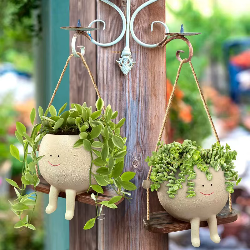 Pot de fleurs créatif en forme de tête de personne assise sur une balançoire