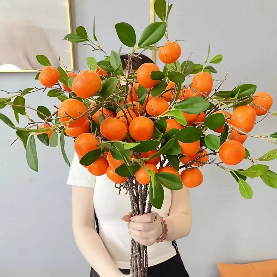 Branche d'orange artificielle avec feuilles vertes réalistes