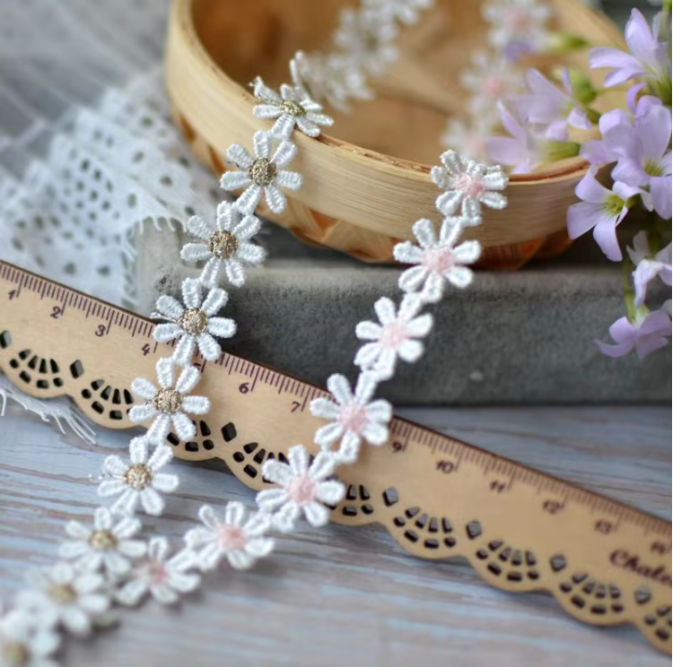 Tissu en dentelle brodée de fleurs de marguerite dorées