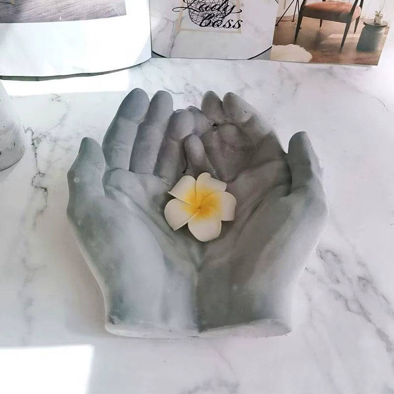 Pot de fleurs en béton en forme de l'hypothèse à la main