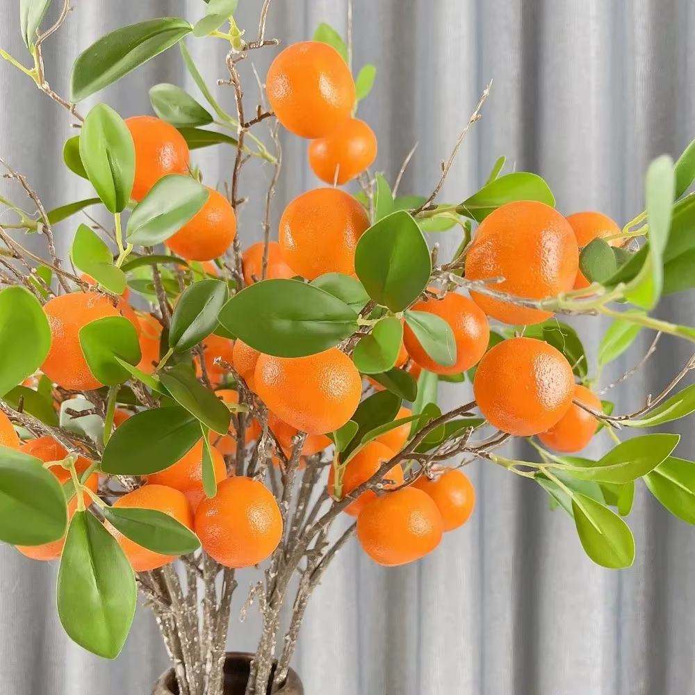 Branche d'orange artificielle avec feuilles vertes réalistes