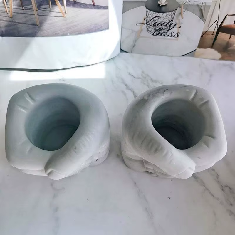 Pot de fleurs en béton en forme de l'hypothèse à la main