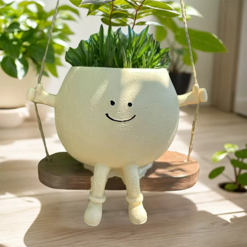 Pot de fleurs créatif en forme de tête de personne assise sur une balançoire