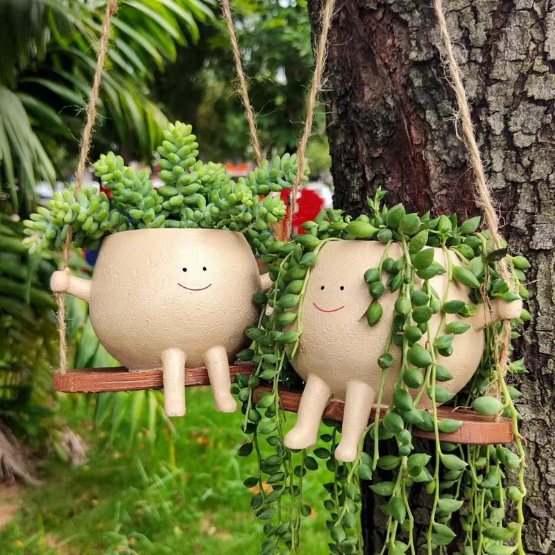Pot de fleurs créatif en forme de tête de personne assise sur une balançoire